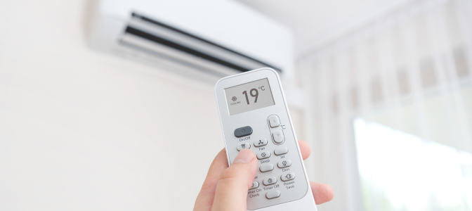 Pessoa usando controle remoto para ajustar 19°C em um split, ilustrando como funciona o ar condicionado