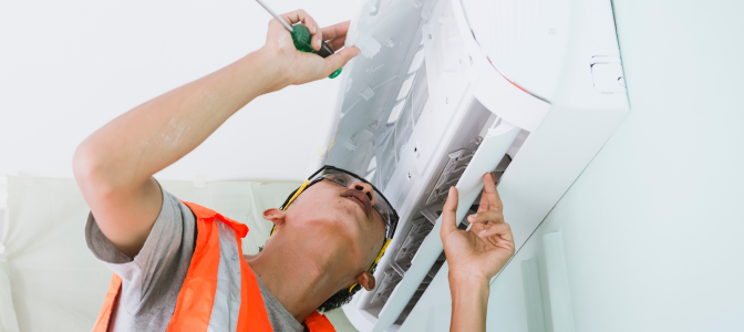 Técnico instalando ar-condicionado na parede, ilustrando orientações sobre onde instalar ar-condicionado no quarto da forma correta